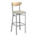 A Lancaster Table & Seating bar stool with a wooden seat and driftwood back and metal legs with a clear coat finish.