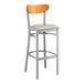 A Lancaster Table & Seating bar stool with a cherry wood back and light gray vinyl seat.