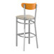 A Lancaster Table & Seating bar stool with a light gray vinyl seat and cherry wood back.