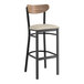 A Lancaster Table & Seating black bar stool with a light gray seat and wood back.