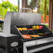 A Louisiana Grills Elite 800 Pellet Grill with a variety of food on it on a table outdoors.