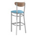 A Lancaster Table & Seating bar stool with a blue vinyl seat and wood back.