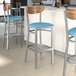 Lancaster Table & Seating Boomerang bar stools with blue vinyl seats and vintage wood backs.