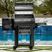 A Louisiana Grills LG800FL Founders Legacy 800 Pellet Grill by a pool.