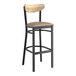 A Lancaster Table & Seating bar stool with taupe cushion and driftwood back with black frame.