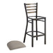 A Lancaster Table & Seating metal ladder back bar stool with dark gray vinyl cushion.