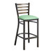 A Lancaster Table & Seating distressed copper metal ladder back bar stool with a seafoam green vinyl padded seat.