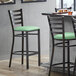A Lancaster Table & Seating ladder back bar stool with a seafoam green vinyl padded seat.