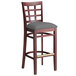 A Lancaster Table & Seating mahogany wood bar stool with a dark gray cushioned seat.