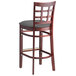 A Lancaster Table & Seating mahogany wood bar stool with a dark gray cushioned seat.