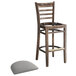 A Lancaster Table & Seating wood bar stool with a light gray vinyl seat