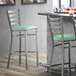 A Lancaster Table & Seating ladder back bar stool with a seafoam vinyl padded seat.