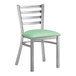 A Lancaster Table & Seating ladder back chair with a green vinyl seat
