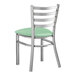 A Lancaster Table & Seating metal ladder back chair with a seafoam green vinyl seat.