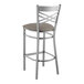 A metal cross back bar stool with a dark gray cushioned seat.