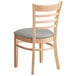 A Lancaster Table & Seating wooden restaurant chair with a light gray vinyl seat and ladder back.