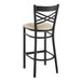 A black bar stool with a light gray cushioned seat.