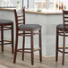 Lancaster Table & Seating Mahogany Finish Wooden Ladder Back Bar Height Chair with Dark Gray Padded Seat Main Thumbnail 1