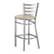 A Lancaster Table & Seating metal ladder back bar stool with a light gray cushion.