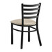 A black Lancaster Table & Seating metal restaurant chair with a light gray cushion.