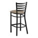 A Lancaster Table & Seating black ladder back bar stool with a taupe cushion.
