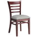 A Lancaster Table & Seating mahogany wood ladder back chair with a light gray vinyl seat