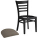 A Lancaster Table & Seating black wood ladder back chair with a taupe vinyl seat detached.
