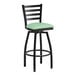 A Lancaster Table & Seating black ladder back swivel bar stool with a seafoam vinyl padded seat.