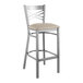 A Lancaster Table & Seating metal cross back bar stool with a light gray cushion.