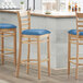 Lancaster Table & Seating Natural Finish Wooden Ladder Back Bar Height Chair with Blue Padded Seat Main Thumbnail 1
