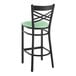 A Lancaster Table & Seating black cross back bar stool with a seafoam green vinyl padded seat.