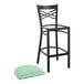 A black Lancaster Table & Seating cross back bar stool with a detached seafoam cushion.