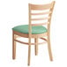 A Lancaster Table & Seating wooden restaurant chair with a seafoam vinyl seat and ladder back.