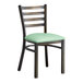 A Lancaster Table & Seating metal ladder back chair with a seafoam green cushion.