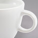 A close-up of an Arcoroc white espresso cup with a handle.