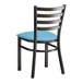 A black Lancaster Table & Seating ladder back chair with a blue vinyl cushion