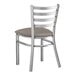 A Lancaster Table & Seating silver metal ladder back chair with a dark gray cushion.