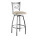 A Lancaster Table & Seating silver cross back swivel bar stool with a light gray cushion.