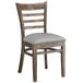 A Lancaster Table & Seating wooden ladder back chair with a light grey vinyl cushion.