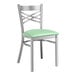 A Lancaster Table & Seating metal cross back chair with a seafoam vinyl cushion.
