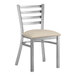 A Lancaster Table & Seating metal ladder back chair with a light gray cushion.