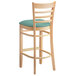 A Lancaster Table & Seating wooden bar stool with a seafoam cushion.