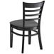 A Lancaster Table & Seating black wooden ladder back chair with a dark gray cushion