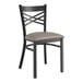 A Lancaster Table & Seating black metal cross back chair with a dark gray padded seat.