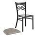 A Lancaster Table & Seating black cross back chair with a dark gray cushion on a white surface.