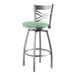 A Lancaster Table & Seating cross back swivel bar stool with a seafoam green cushion.