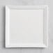 A Fortessa Fortaluxe Tavola bright white square porcelain plate on a gray surface.