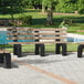 A group of MasonWays cedar benches with black legs next to a pool.