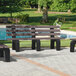 A brown MasonWays Dura-Bench with black legs in a park.