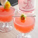 Two glasses of Lyre's Pink London Spirit with a lemon and a stick on top.